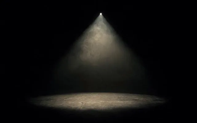 The Star Turn hero frame: a spotlit stage in haze