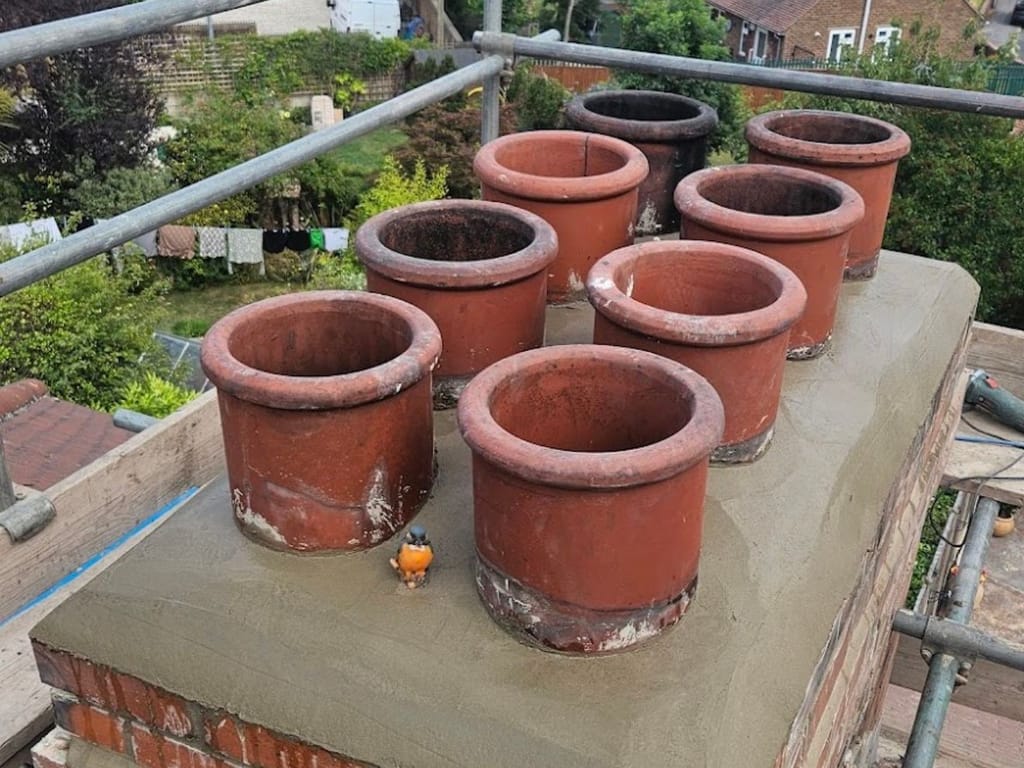 Eight new terracotta chimney pots set on a freshly rebuilt brick chimney stack