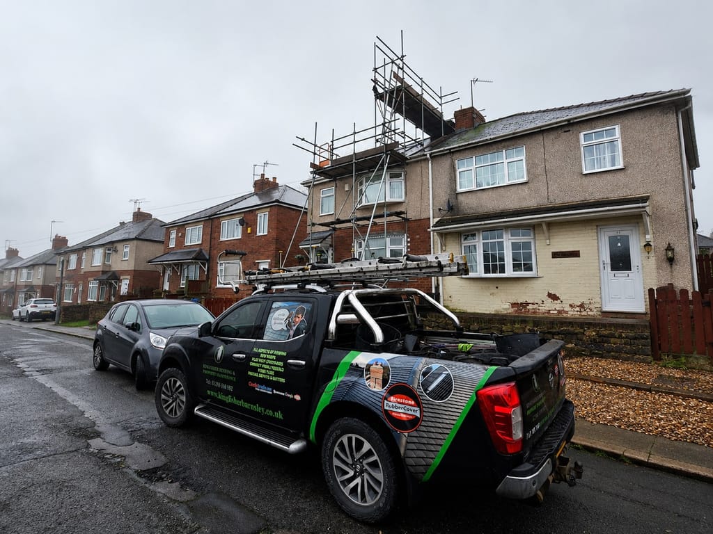 Pennine Roof Co van and scaffold tower outside a brick terrace mid-roof