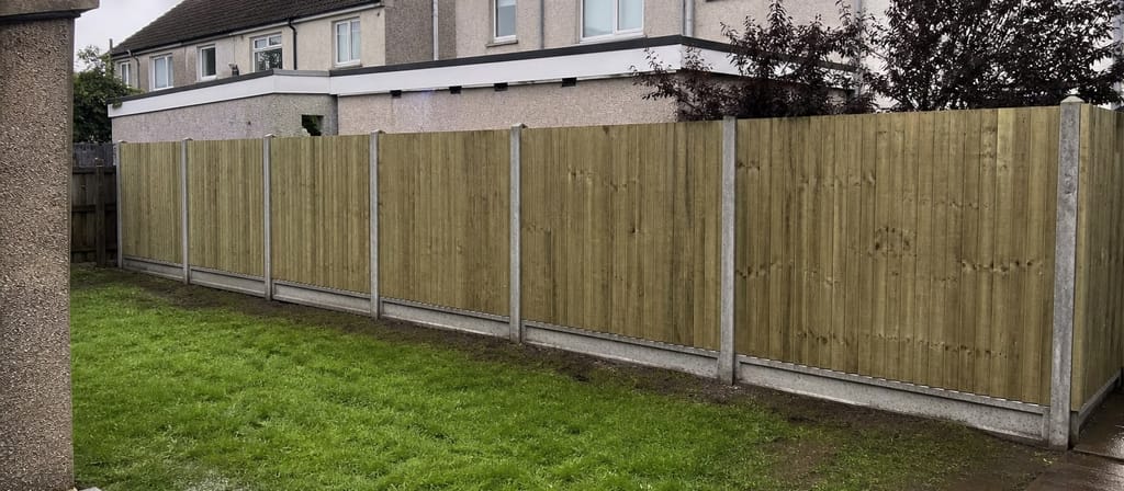 Ordinary post-war semis in Kingswood, closeboard fencing on concrete posts running between the back gardens