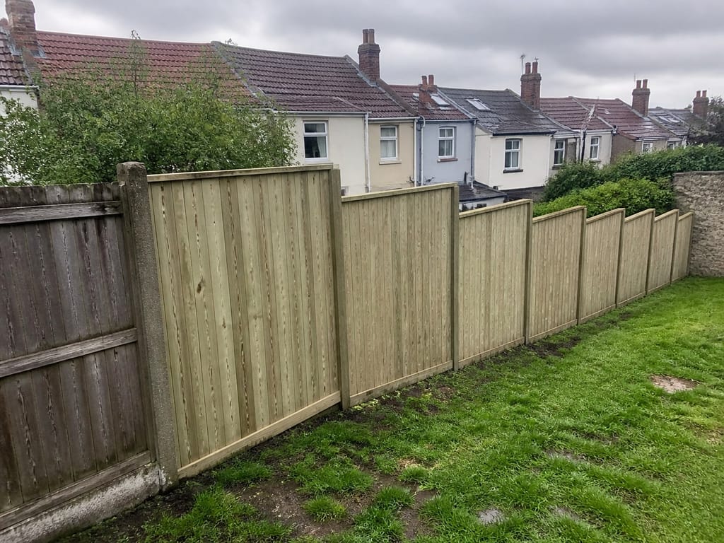 A closeboard run stepped down a sloping garden, each bay level and the steps between them even
