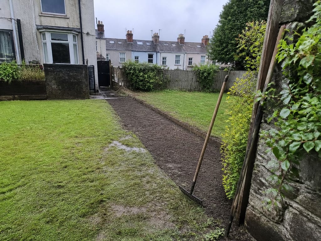 The old fence loaded out and the ground raked off along the line, with the spoil cleared and the grass edge tidied