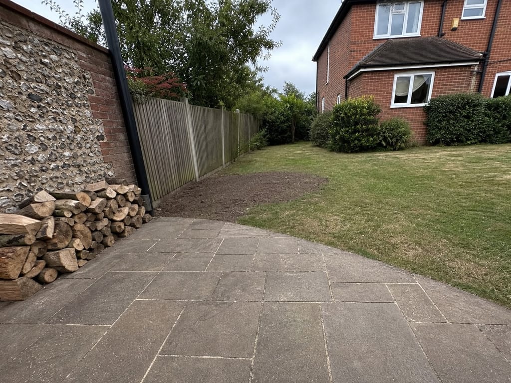 Site raked and swept before we leave, the patio brushed clean and the logs stacked against the flint wall